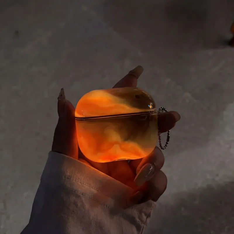 Hand holding a glowing molten orange spherical object against a dark background