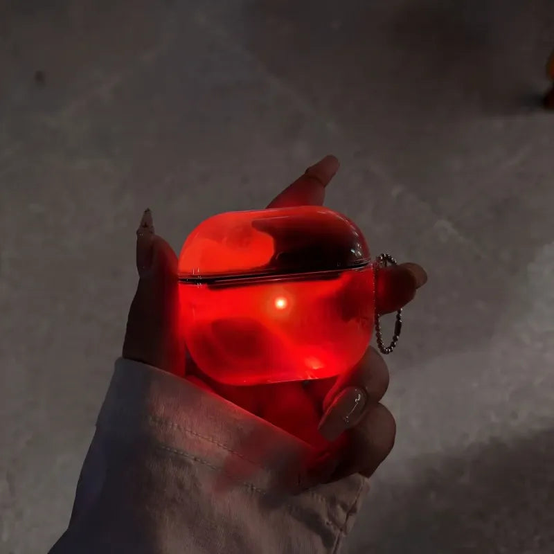Hand holding a crimson red glowing object against a dark background